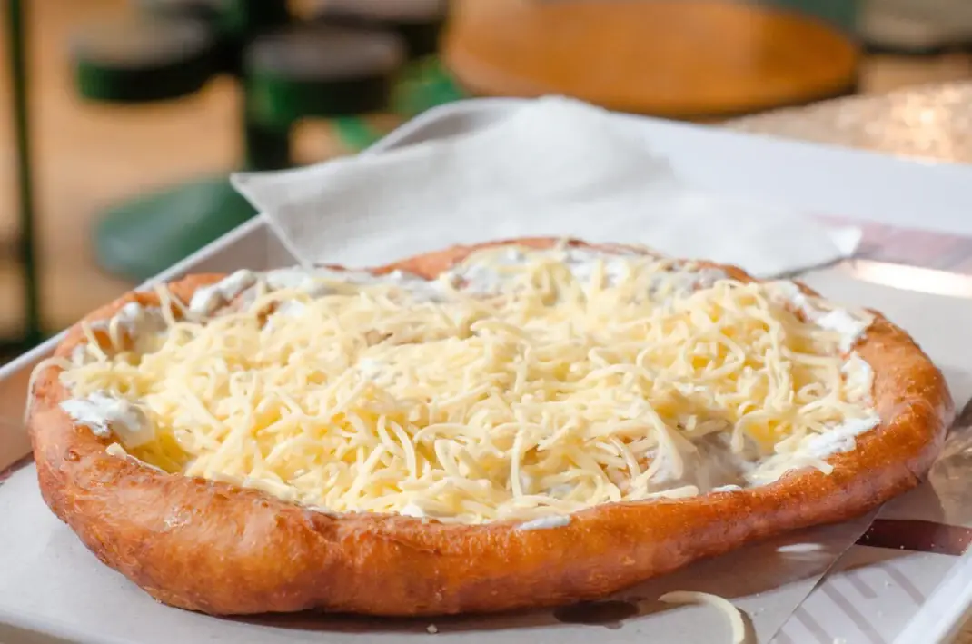 An image of a plate of traditional Hungarian food, including Goulash and Langosh